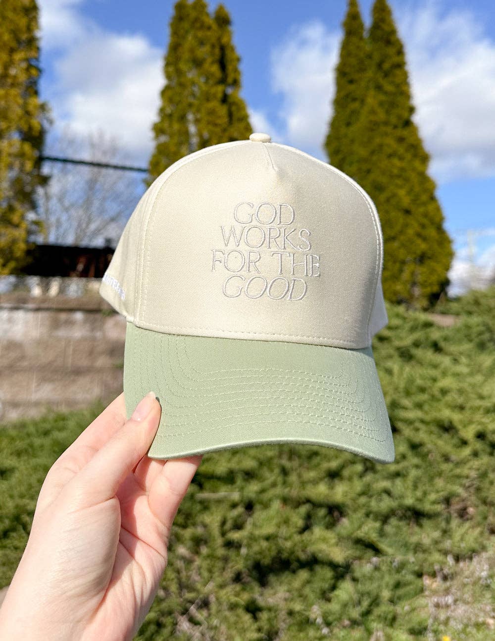 God Works for the Good Trucker Hat